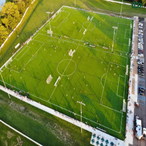 Aerial view of a large outdoor sports complex featuring multiple synthetic turf football pitches.