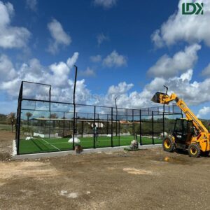 Glass padel court construction process in Bonaire with lifting equipment