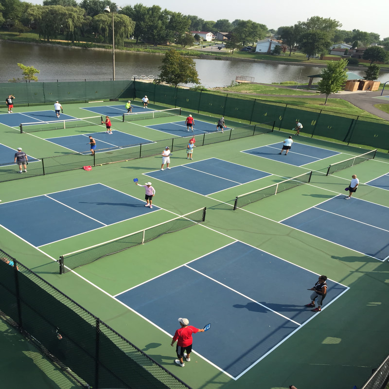 Aerial view of outdoor pickleball courts with players in action, showing LDK sports flooring in use