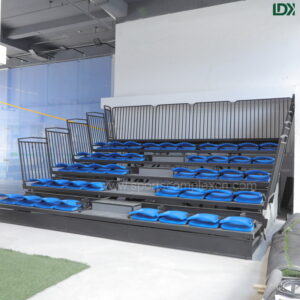 Side view of LDK telescopic bleachers, electric retractable structure with safety guardrails for commercial sports facilities
