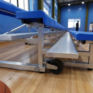 Close up detail of non-marking caster wheels and sturdy aluminum frame on portable indoor basketball bleachers.