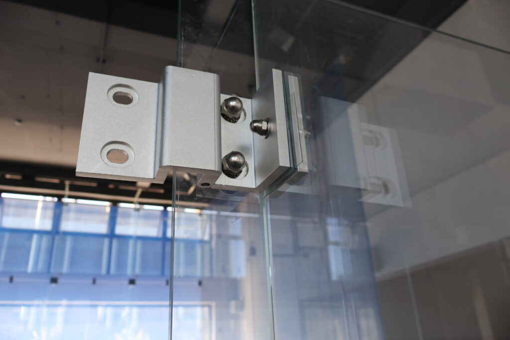 glass squash court aluminum alloy hardware fittings Close-up of heavy-duty aluminum alloy hardware fittings used to secure glass squash court walls.